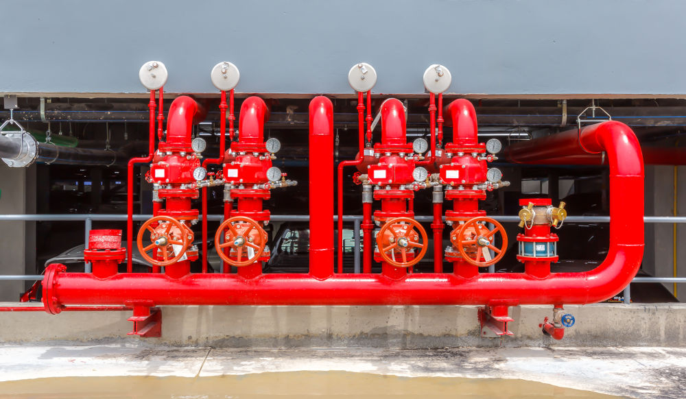 Red fire sprinkler piping with control valves and pressure gauges